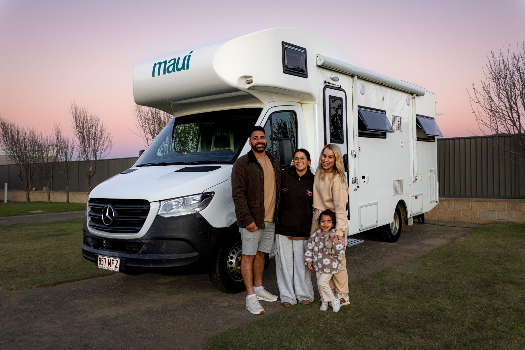 Cole with his family beside a campervan